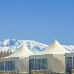 Panoramic Agafay desert luxury camp with Atlas Mountains in background