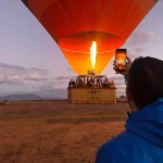 Hot air balloon Marrakech Morocco floating above sunrise desert