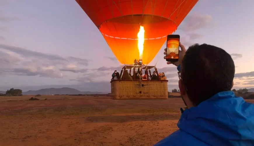 Hot air balloon Marrakech Morocco floating above sunrise desert